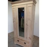 Late Victorian stripped pine single mirrored door wardrobe, with single drawer to the base and