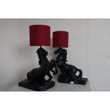 Pair of black finished table lamps modelled as rearing horses, with red shades (2)