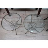 A pair of early 1960s wrought iron circular occasional tables with inset glass tops on three sputnik