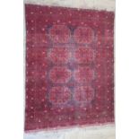 Bokhara red ground rug, the field filled with repeating geometric motifs within a similar multi