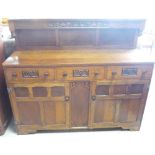1930s oak sideboard with raised carved and panelled back, above three drawers and two panelled