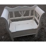 White painted bench seat with open work back and sides and lifting seat cover, on square supports (