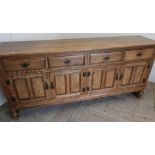 Quality modern oak sideboard with four drawers above four paneled cupboard doors on raised