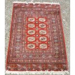 20th C Caucasian style red ground rug, with geometric pattern field (205cm x 140cm)