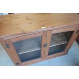 Modern pine side cabinet enclosed by pair of glazed doors (118cm x 48cm x 82cm)