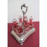 Continental silver plated shaped rectangular six bottle cruet, with six red overlay cut bottles,