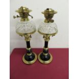 Pair of elaborate 19th C oil lamps with ebonised columns and brass mounts, with cut glass dome