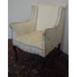 Small Edwardian upholstered armchair, shaped wing back and serpentine seat on slender cabriole