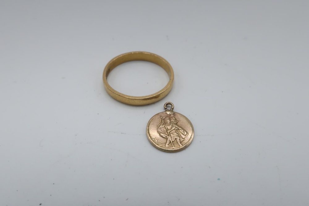 22ct gold hallmarked wedding band, 3.6g and a 9ct gold hallmarked St. Christopher charm, 4.6g