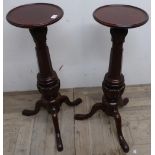 Pair of mahogany tripod torchere, dish turned tops on faceted supports with three splayed legs (84cm