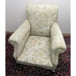 Victorian upholstered armchair with shaped back and arms, on angular cabriole legs with castors