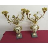 Pair of gilt metal and onyx urn shaped twin branched candelabra on square marble base, with goat