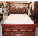 Chiang Su red lacquered elm canopy bed, pierced headboard with gilt carved panels, the base with six