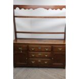 George III oak dresser, twin shelf back with shaped frieze above two real and one faux drawers