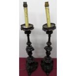 A pair of 17/18th continental carved walnut candle stand converted to electric.(H74cm) (1AF)