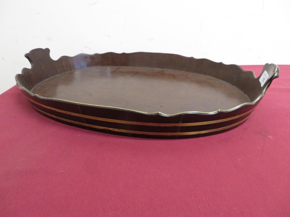 Early 19th C mahogany twin handled oval tray, with brass bound waved gallery (53cm x 37cm).