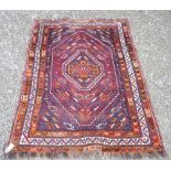 20th C Caucasian pattern red ground rug with geometric central medallion and stylised geometric
