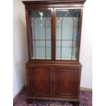 George III mahogany bookcase with dentil cornice above a pair of Gothic astragal glazed doors, the