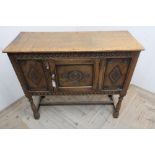 17th C style oak low side cabinet, with overhanging top, and scroll carved frieze above two