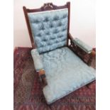 Edwardian walnut framed salon armchair with deep button upholstered back and carved pierced arms