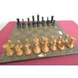 Large turned boxwood and ebonized chess set, on John Jaques chess board with alternate carved rose
