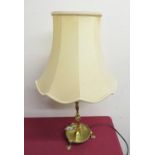 Brass table lamp, on turned column with circular dished base on three pad feet