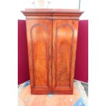 Victorian mahogany wardrobe, with moulded cornice enclosed by a pair of arch moulded panel doors, on