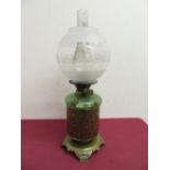 Early 20th C Duplex oil lamp with green reservoir standing in an embossed cylindrical container on