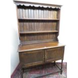 20th C oak dresser, with twin shelf boarded back above two cupboard doors on turned supports