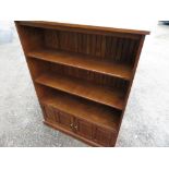 Cryer Craft elm bookcase with boarded back and two shelves above two two-paneled doors on plinth