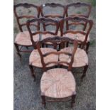 Set of six French oak ladderback rush seated dining chairs, the top rail with carved shell detail