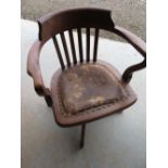 Early 20th C oak swivel office armchair with shaped slat back and brass nailed seat on four