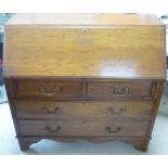19th C oak bureau with fall front revealing fitted interior above two short and two long drawers, on