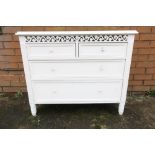 White painted chest of two short above two long drawers with fretwork panel to the top W91cm D37cm