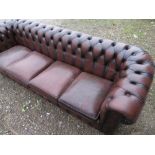 Large brown leather Chesterfield sofa with deep button back and arms, and four seat cushions