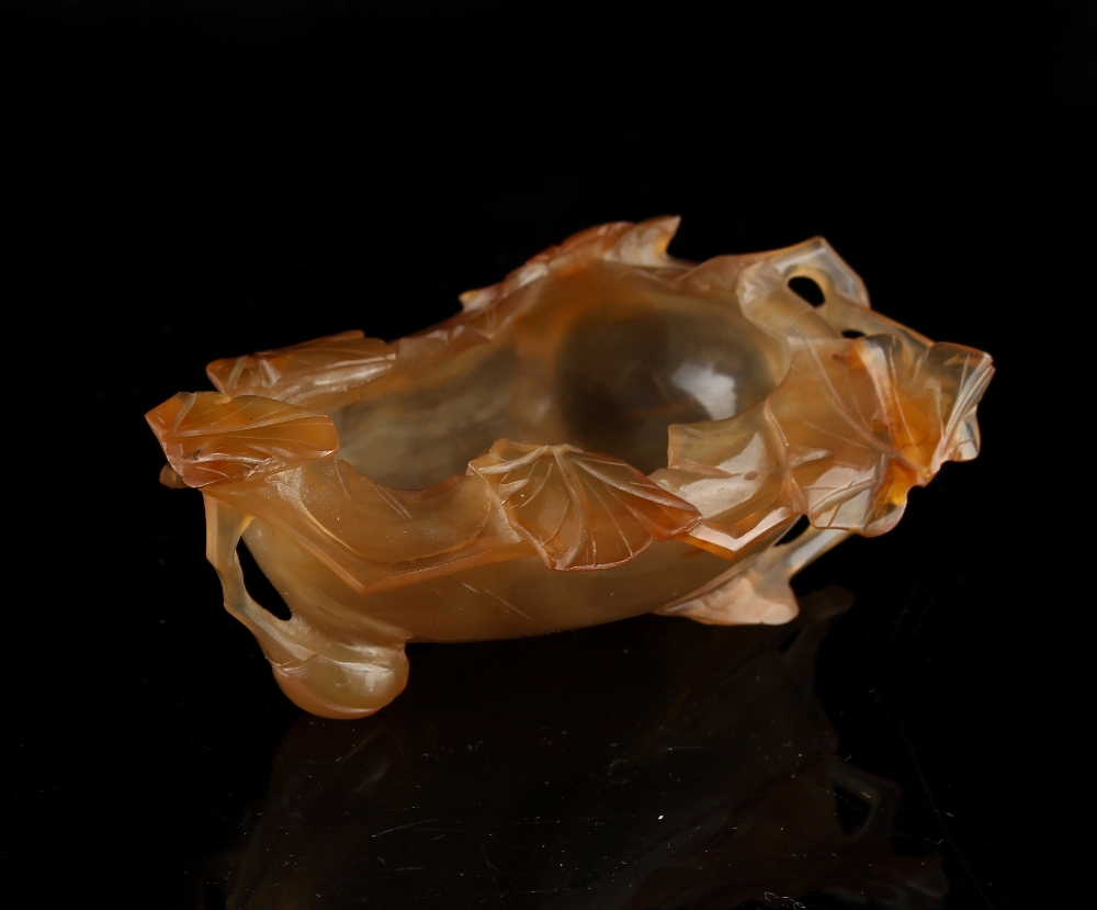 A Chinese agate leaf brushwasher, 3.7ins. (9.4cms.) long, with later associated hardwood stand.