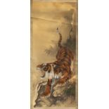 An early 20th century Japanese scroll painting on silk depicting a tiger by a stream, signed &