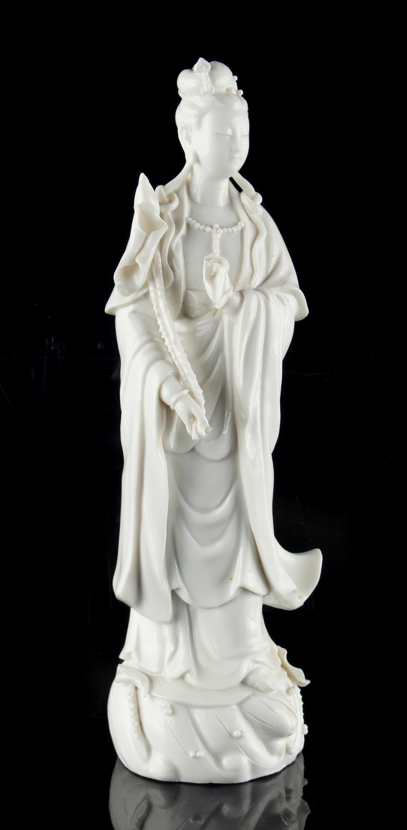 A Chinese blanc de Chine figure of Guanyin, 20th century, modelled standing & holding a lotus