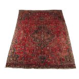 A Meshed woollen hand-made carpet with red ground, 108 by 87ins. (274 by 221cms.).