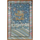 A 19th century Chinese kesi panel depicting a dragon chasing a flaming pearl above waves,
