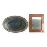 Property of a gentleman - Liberty - an embossed brass oval framed wall mirror, with bevelled