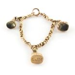 Property of a lady - a yellow gold (tests 14/15ct) charm bracelet with three seals (all test 14/