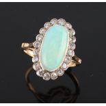 An unmarked yellow gold opal & diamond oval cluster ring, the oval opal weighing an estimated 2.83