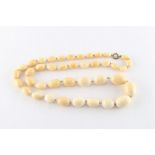 Property of a lady - a good long 19th century ivory graduated oval bead necklace, the largest of the