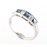 An Art Deco style sapphire & diamond ring, with alternating square cut sapphires & baguette cut