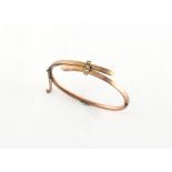 Property of a lady - a late Victorian 9ct gold hinged bangle of crossover design set with three seed