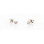 Property of a lady - a pair of 18ct white gold diamond stud earrings, each set with a single round