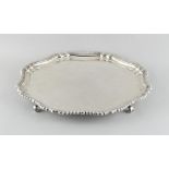 Property of a lady - a George II style silver salver or waiter, plain centre with gadrooned edge, on