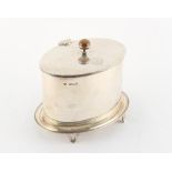 Property of a lady - a silver oval biscuit box, the hinged lid with engraved family crest,