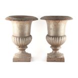 Property of a gentleman - a pair of silver painted cast iron garden urns, each 12.2ins. (31cms.)